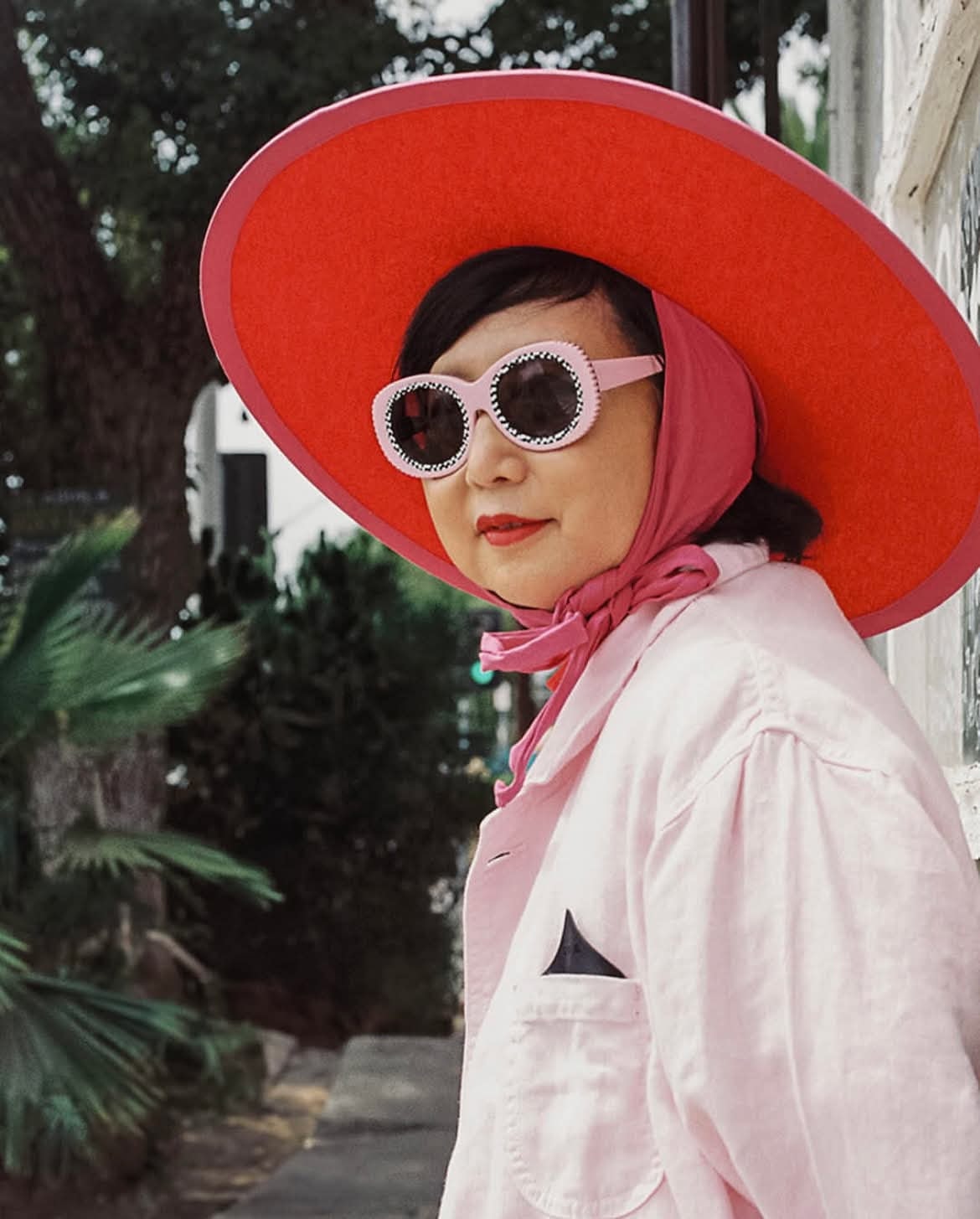 Pink round sunglasses with red wide-brim hat